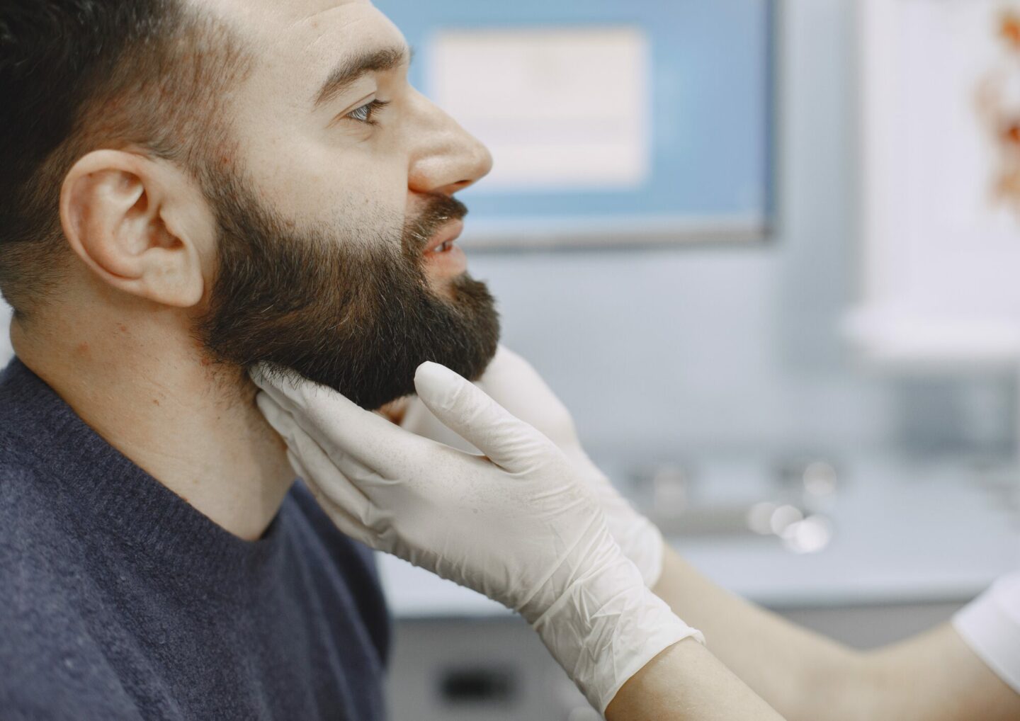 Male patient's neck being examined by healthcare professional.